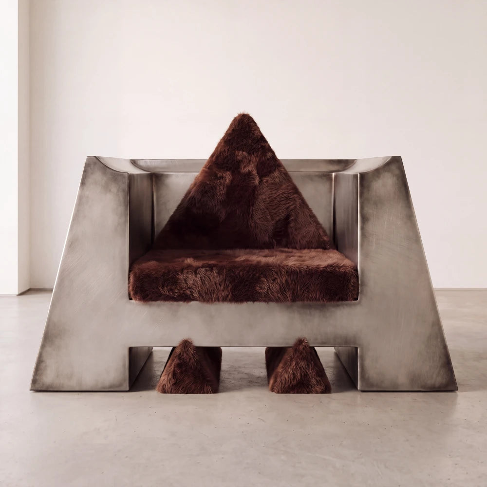 Front view of the Totem armchair by Diamant Versatile, combining a monumental brushed metal shell with dark brown fur upholstery.